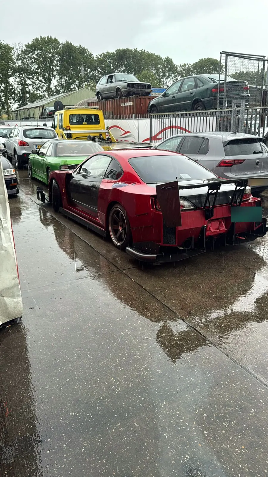 Rode Nissan Silvia S15 met widebody en achtervleugel op het terrein van Senna Auto Service